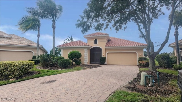 6733 Bent Grass Dr, Naples, FL 34113 - mediterranean / spanish home with stucco siding, decorative driveway, a tiled roof, and a garage