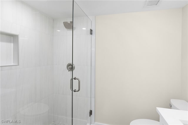 full bathroom featuring visible vents, vanity, a shower stall, and toilet