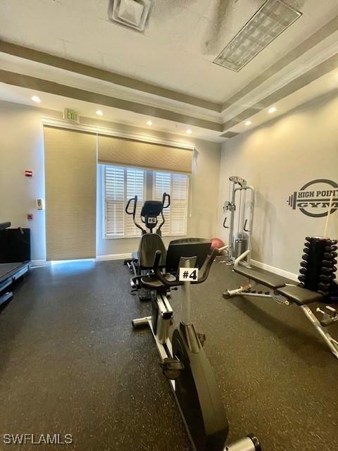 workout area with recessed lighting, a raised ceiling, visible vents, and baseboards