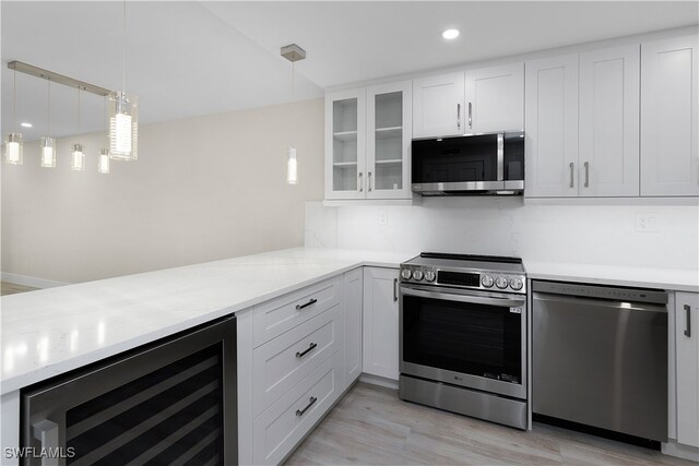 kitchen with wine cooler, stainless steel appliances, light wood-style flooring, glass insert cabinets, and white cabinets