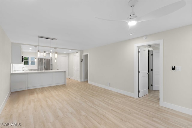 unfurnished living room featuring baseboards and light wood-style floors