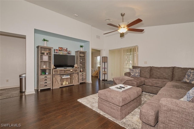 living room featuring dark wood-type flooring, ceiling fan, and vaulted ceiling