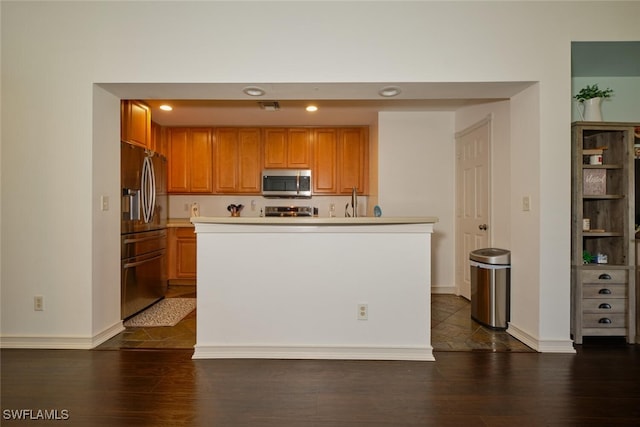 kitchen with dark hardwood / wood-style floors and appliances with stainless steel finishes