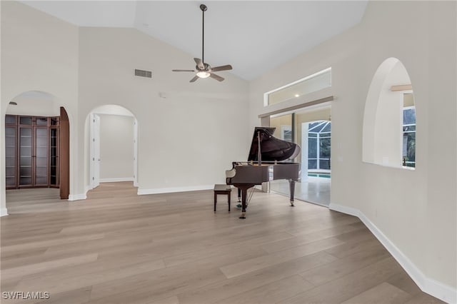 interior space featuring high vaulted ceiling, ceiling fan, and light wood-type flooring