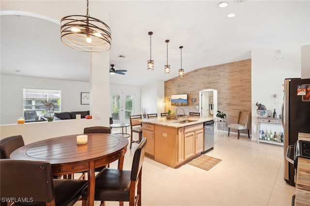 kitchen featuring a wealth of natural light, a center island with sink, and decorative light fixtures