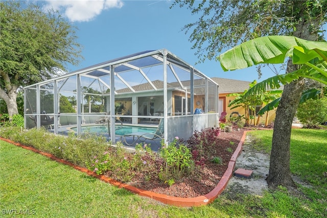 view of swimming pool with a lanai and a lawn