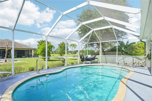 view of swimming pool featuring a patio, a yard, and a lanai