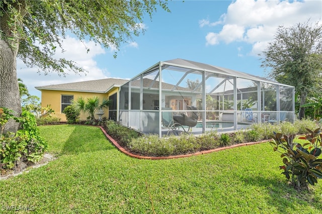 back of house featuring a lawn and glass enclosure