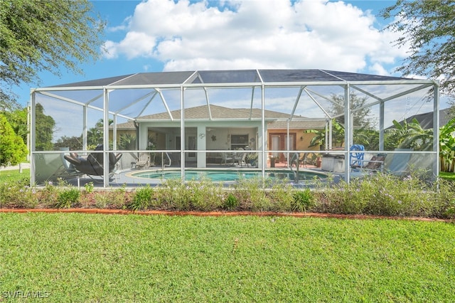 rear view of property with a yard, glass enclosure, and a patio