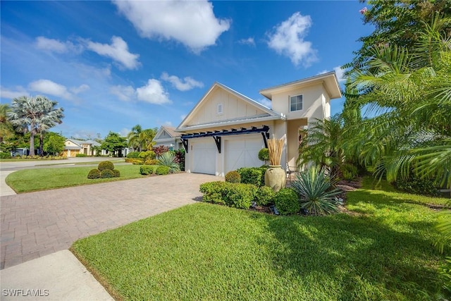 view of front of property with a garage, decorative driveway, board and batten siding, and a front yard