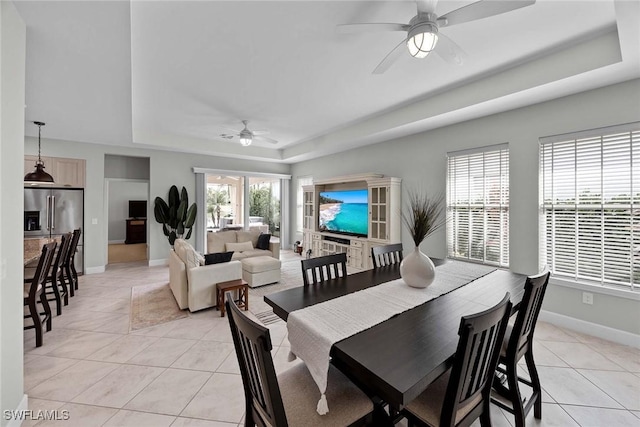 14151 Nautica Ct, Naples, FL 34114 - dining room with a ceiling fan, a tray ceiling, baseboards, and light tile patterned floors