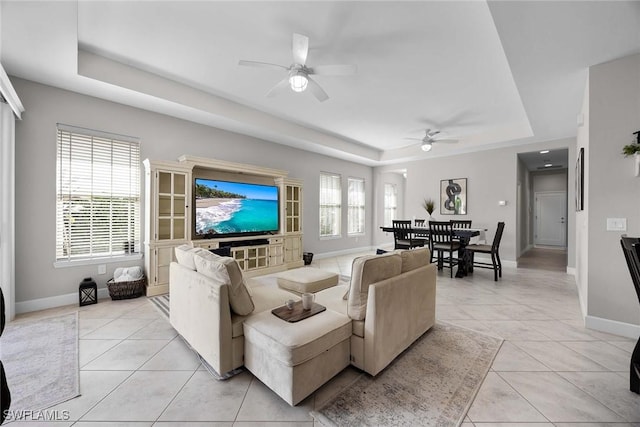 14151 Nautica Ct, Naples, FL 34114 - living area featuring light tile patterned floors, a raised ceiling, and baseboards