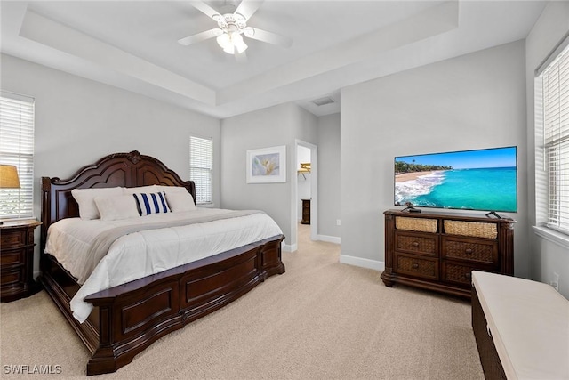 14151 Nautica Ct, Naples, FL 34114 - bedroom featuring baseboards, multiple windows, a tray ceiling, and light colored carpet