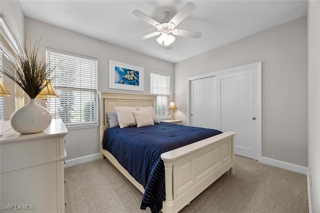 14151 Nautica Ct, Naples, FL 34114 - bedroom featuring light carpet, multiple windows, a closet, and baseboards