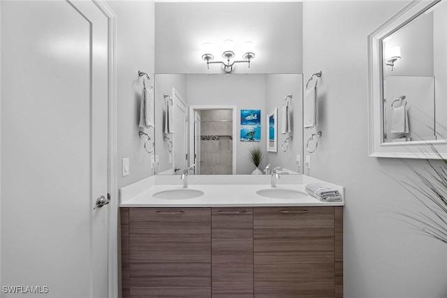 14151 Nautica Ct, Naples, FL 34114 - bathroom featuring a sink, a tile shower, and double vanity