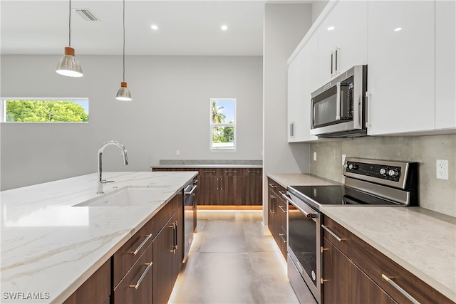 kitchen with a healthy amount of sunlight, stainless steel appliances, and white cabinets