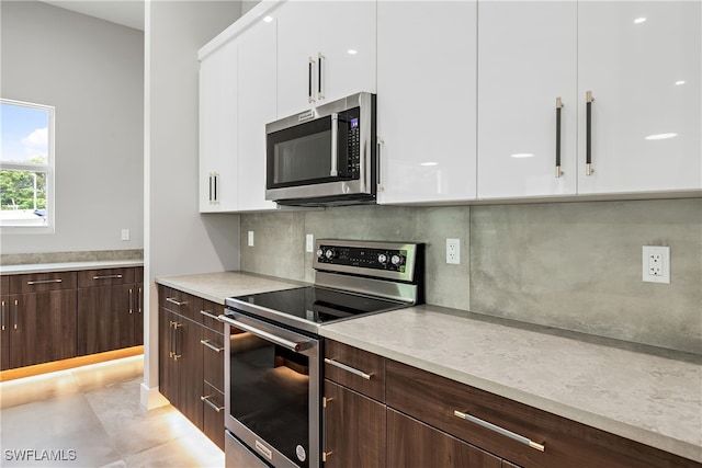 kitchen with backsplash, light tile patterned floors, stainless steel appliances, white cabinets, and dark brown cabinetry