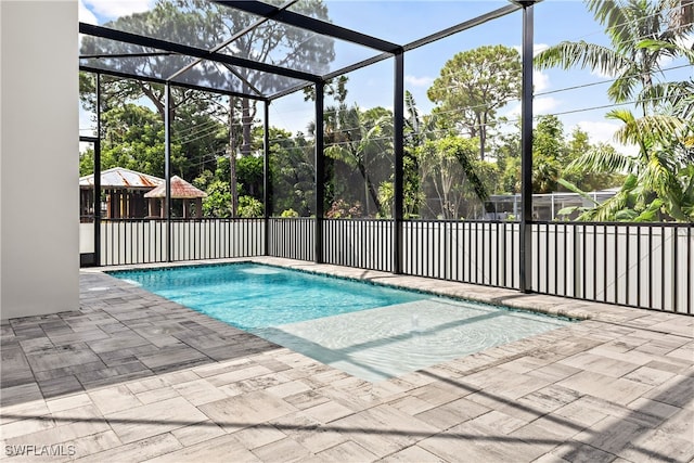 view of pool featuring glass enclosure and a patio