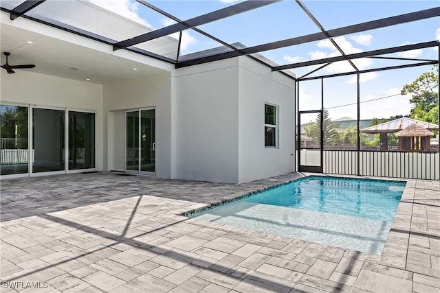 view of pool with ceiling fan, a lanai, and a patio area