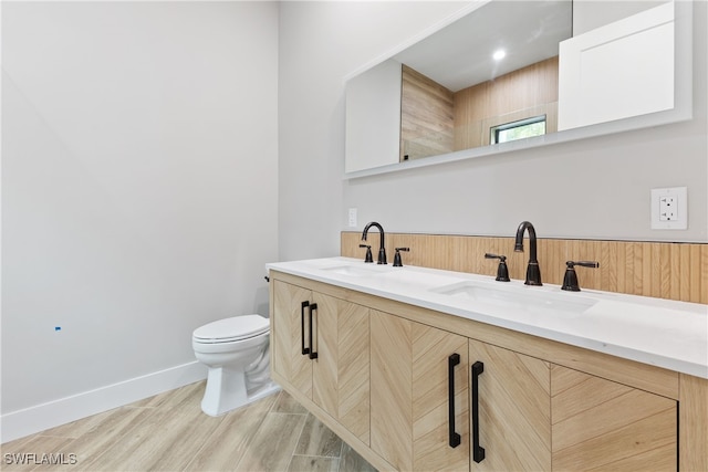 bathroom with vanity, toilet, and hardwood / wood-style floors