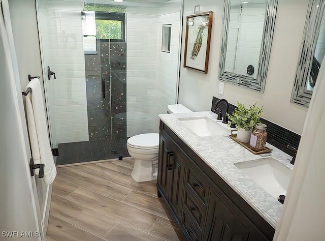 bathroom with tiled shower, toilet, and vanity