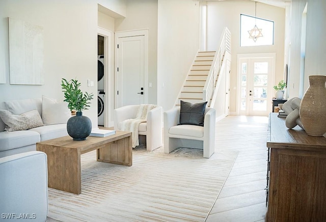 living room featuring a notable chandelier and stacked washer / drying machine