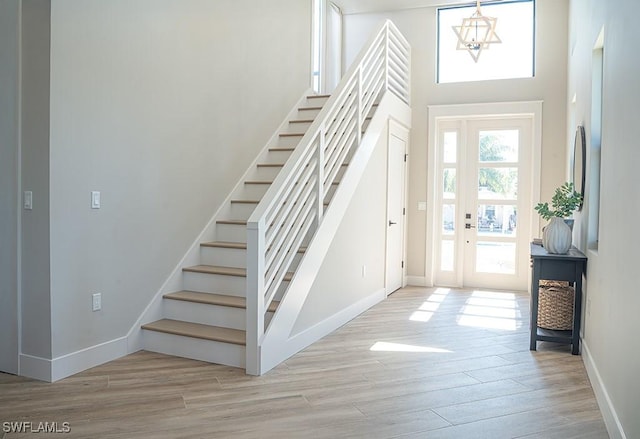 foyer with light wood-type flooring and a chandelier