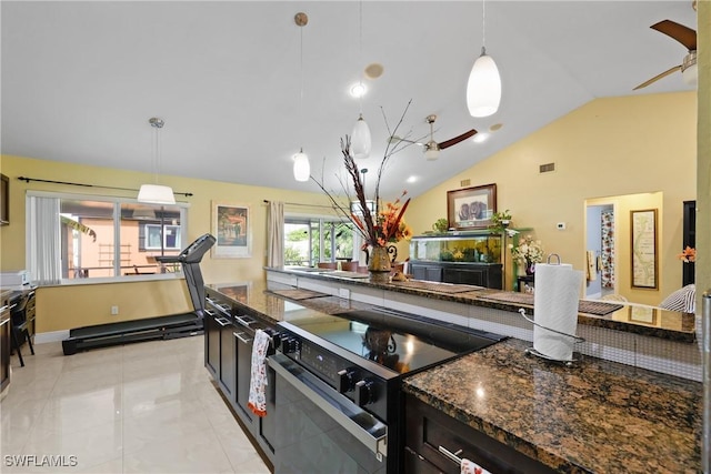 kitchen featuring light tile patterned floors, lofted ceiling, hanging light fixtures, and stainless steel range with electric cooktop