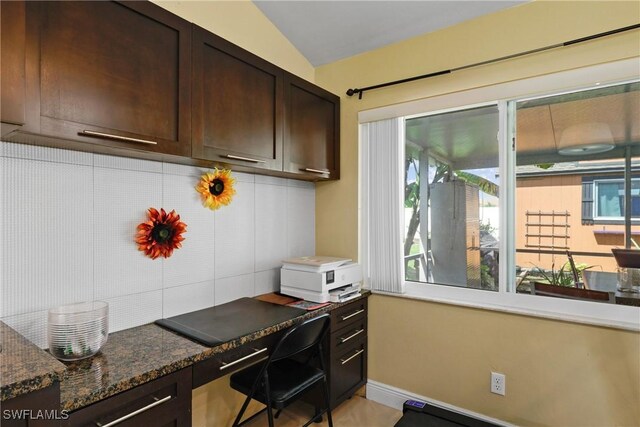 office space with built in desk and vaulted ceiling