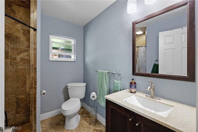 bathroom with vanity, curtained shower, and toilet