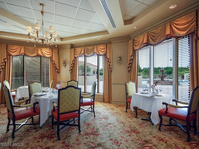carpeted dining room with a raised ceiling and a notable chandelier