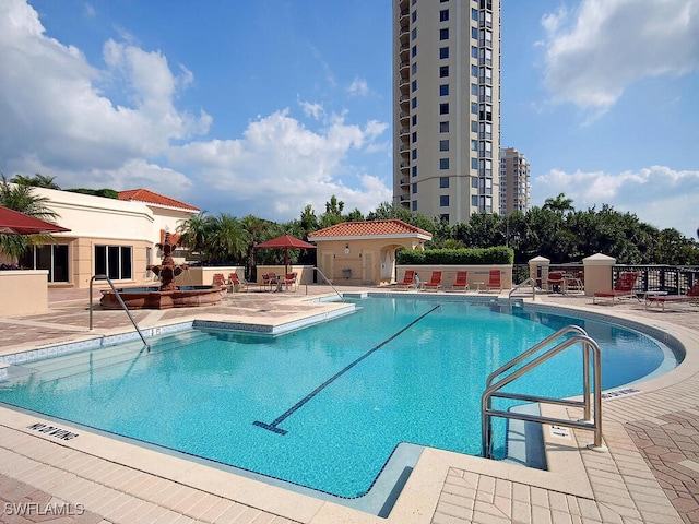 community pool with a patio and fence