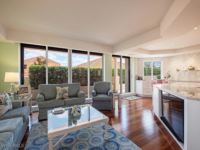 living room featuring dark wood-type flooring, recessed lighting, and beverage cooler