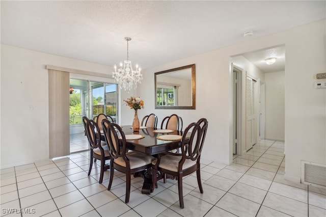 dining space with light tile patterned flooring, a textured ceiling, and an inviting chandelier