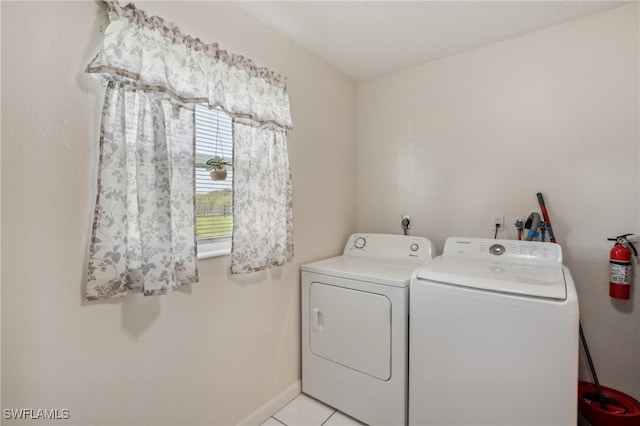 laundry area with washer and dryer and light tile patterned flooring