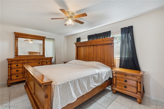 bedroom with a textured ceiling, ceiling fan, and light tile patterned flooring