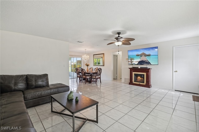 tiled living room featuring a textured ceiling and ceiling fan with notable chandelier