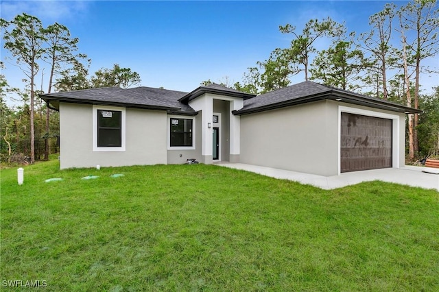 view of front of home with a garage and a front lawn