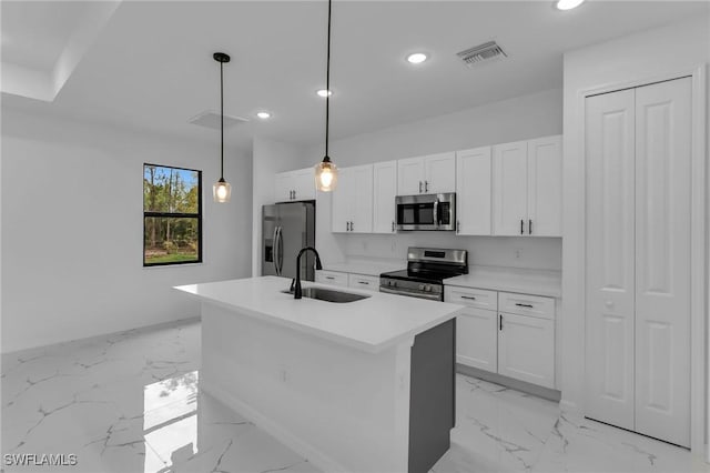 kitchen featuring stainless steel appliances, sink, white cabinetry, pendant lighting, and a kitchen island with sink