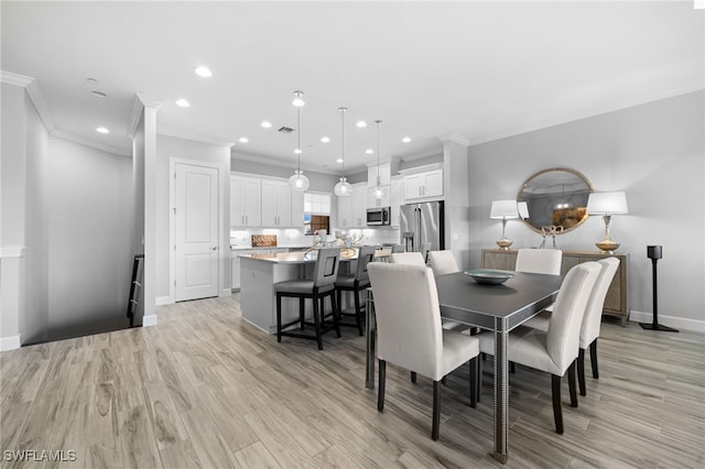 dining area with light wood-type flooring and ornamental molding