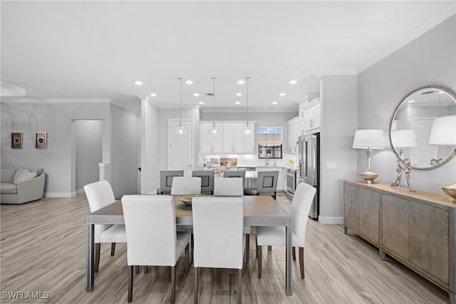 dining space featuring ornamental molding, light wood finished floors, recessed lighting, and baseboards