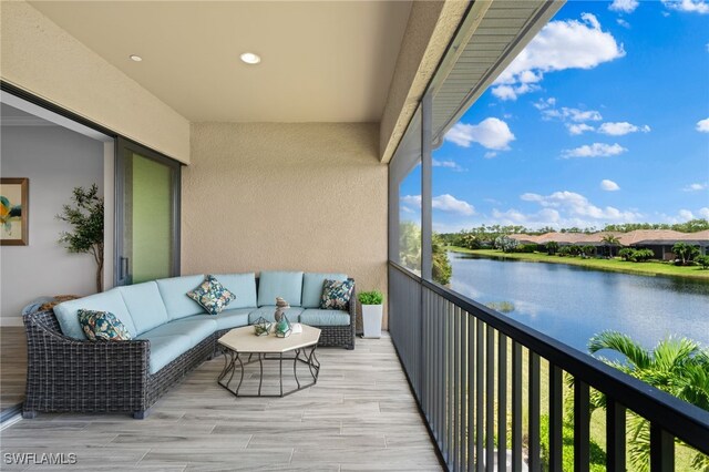 balcony featuring an outdoor living space and a water view