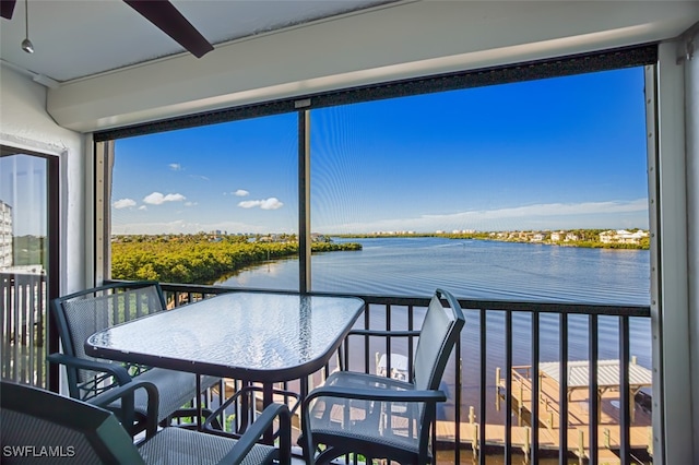 sunroom featuring a water view