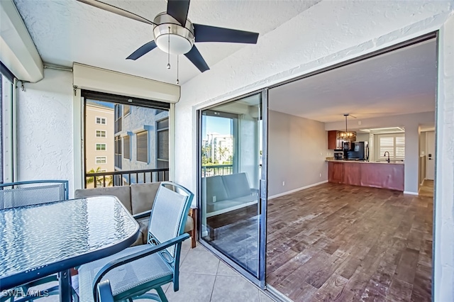 sunroom featuring ceiling fan and sink