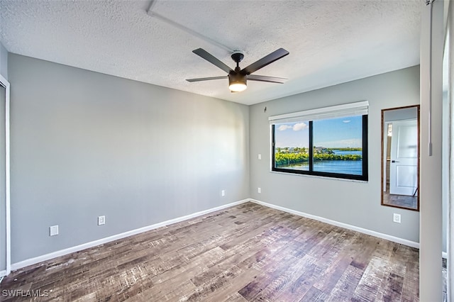 unfurnished room featuring hardwood / wood-style floors, ceiling fan, and a textured ceiling