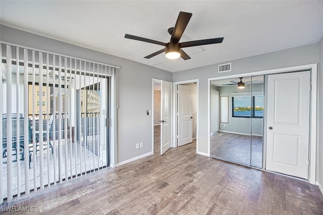 interior space with hardwood / wood-style floors, ceiling fan, a closet, and a textured ceiling