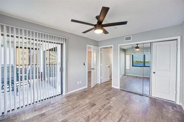 4835 Bonita Beach Rd Unit 408, Bonita Springs, FL 34134 - unfurnished bedroom featuring multiple windows, wood finished floors, visible vents, and baseboards