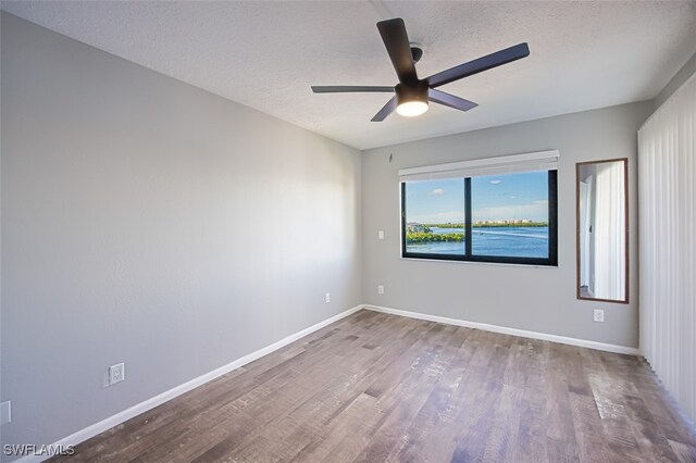 4835 Bonita Beach Rd Unit 408, Bonita Springs, FL 34134 - empty room featuring a textured ceiling, ceiling fan, wood finished floors, and baseboards