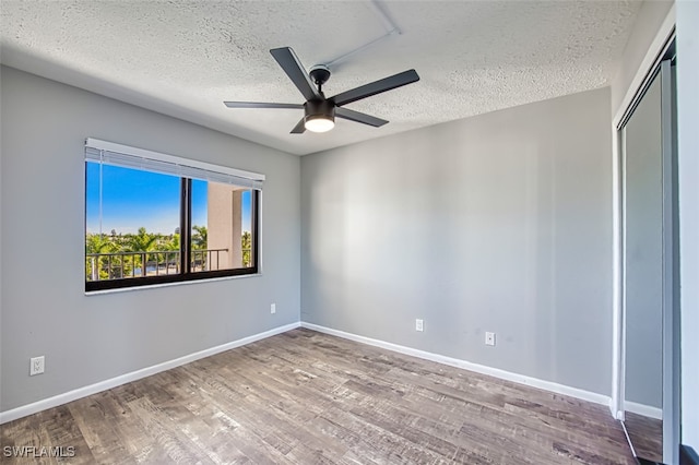 unfurnished room with ceiling fan, hardwood / wood-style flooring, and a textured ceiling