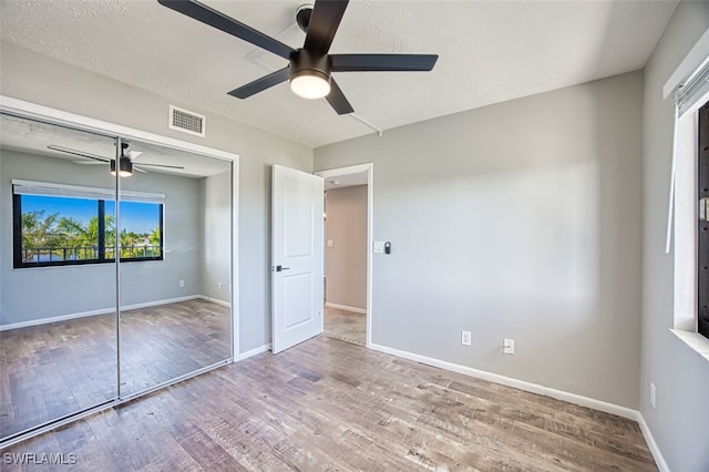 4835 Bonita Beach Rd Unit 408, Bonita Springs, FL 34134 - unfurnished bedroom featuring a closet, visible vents, a ceiling fan, wood finished floors, and baseboards